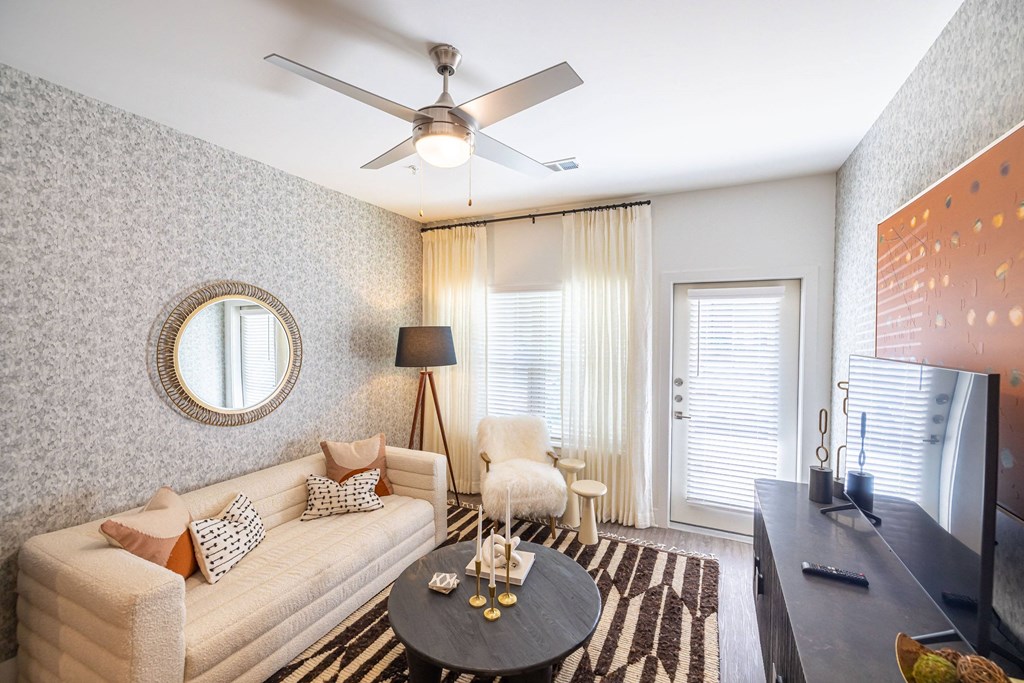 a living room with a couch and a ceiling fan