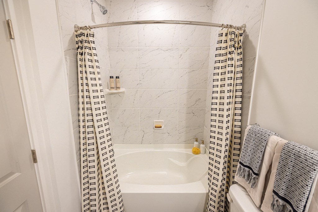 a small bathroom with a tub and a shower curtain