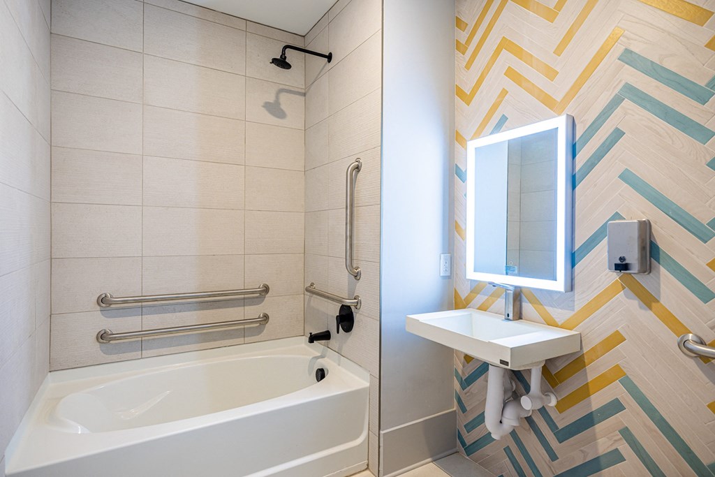 a bathroom with a tub and a sink and a mirror