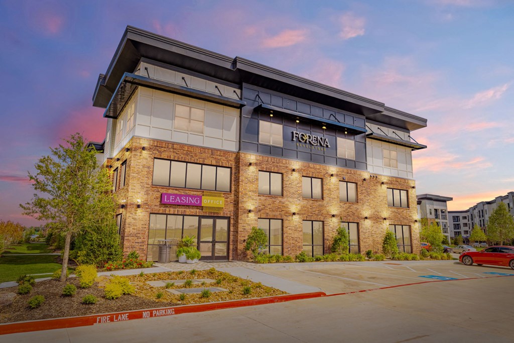 an office building with the facade lit up at sunset