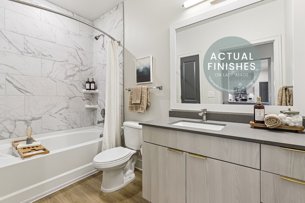 A white bathroom with a tub, toilet, and sink.