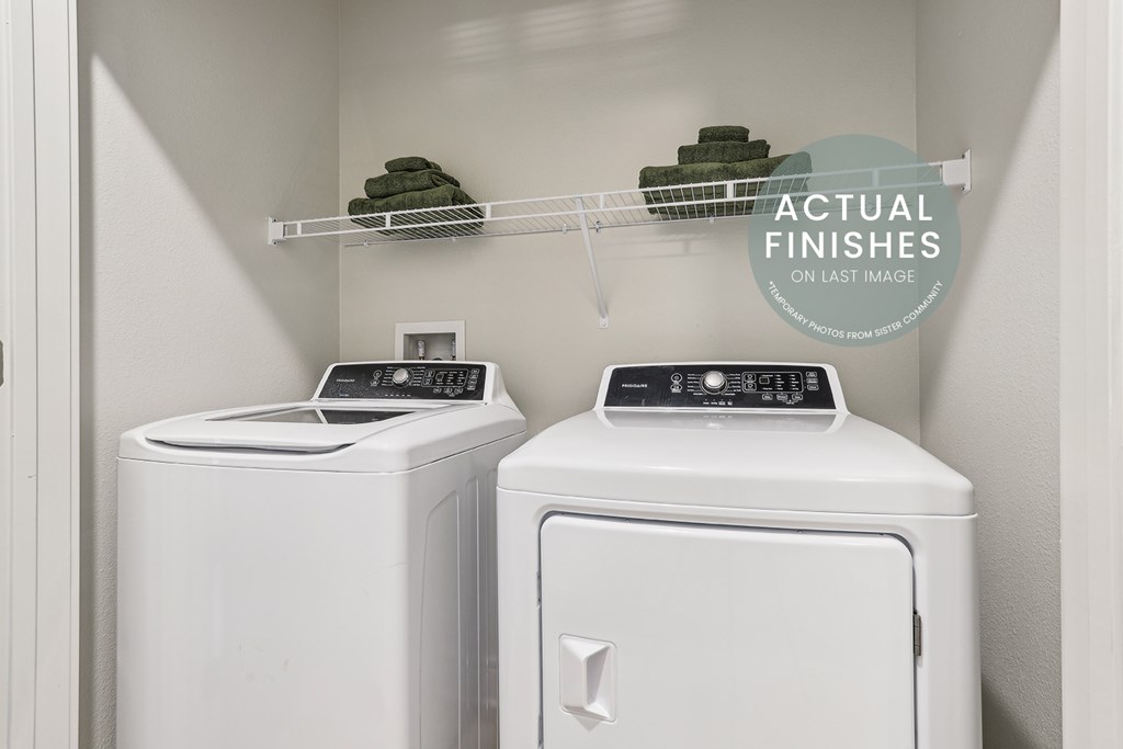 Two white front loading washing machines in a laundry room.