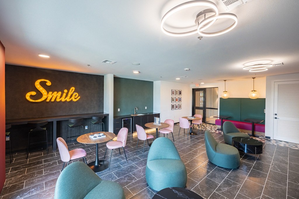 a lobby with a smile sign and chairs and tables