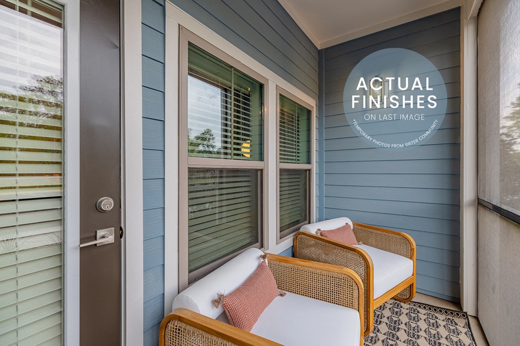 a small porch with two wicker chairs and a door