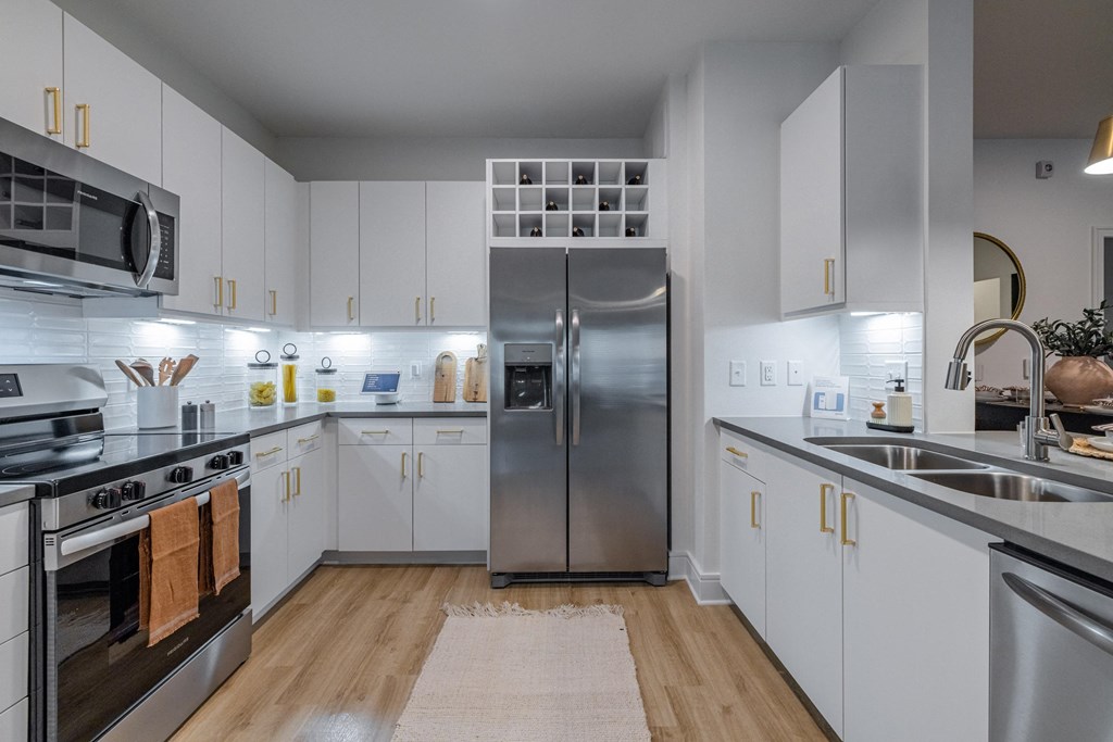 a large kitchen with stainless steel appliances and white cabinets