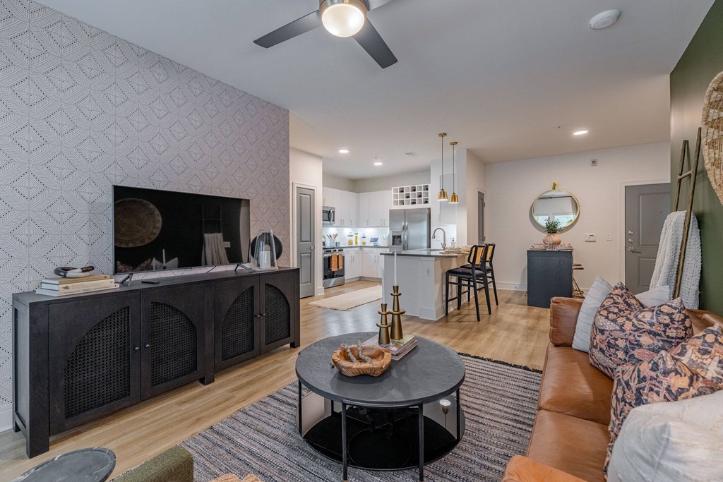 a living room with a fireplace and a kitchen in the background