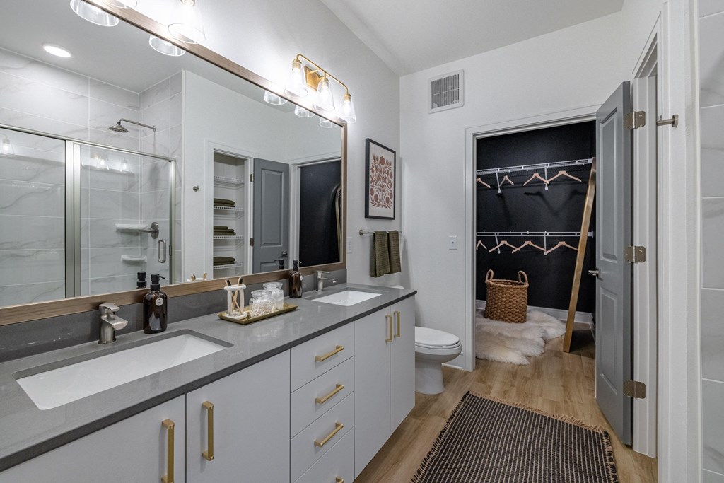 a bathroom with two sinks and a shower and a toilet