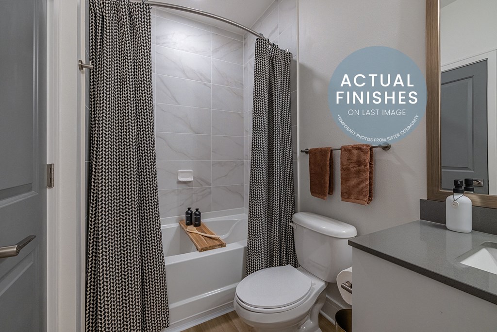 a bathroom with a toilet and a tub and a shower curtain