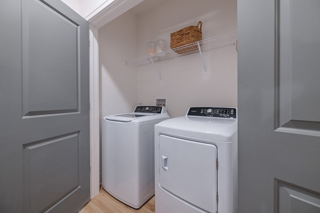 a washer and dryer in a laundry room with gray walls and a door