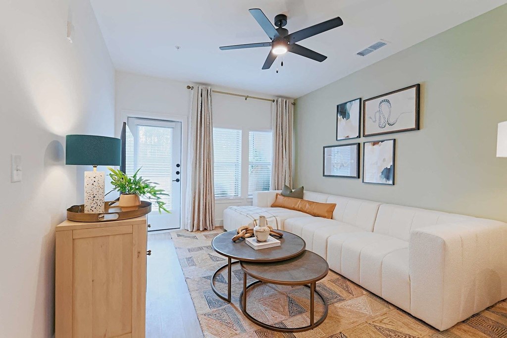 a living room with a white couch and a ceiling fan