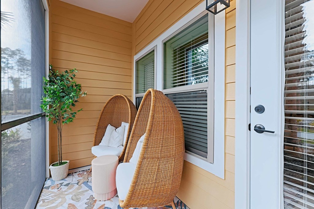 a small porch with two chairs and a window