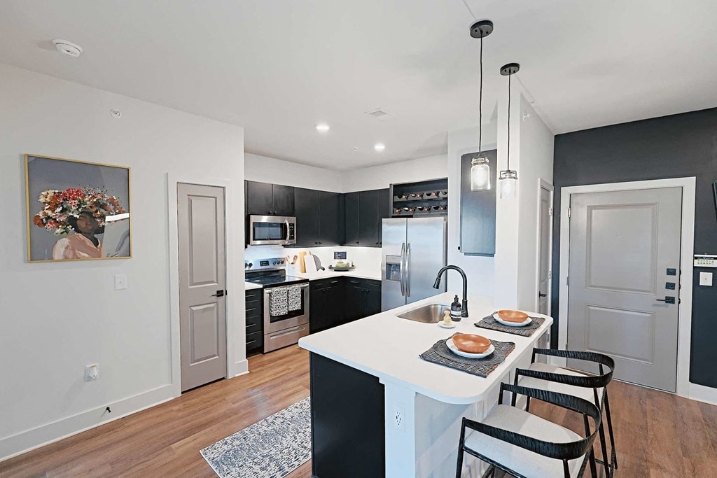 a kitchen with a white counter top and black cabinets
