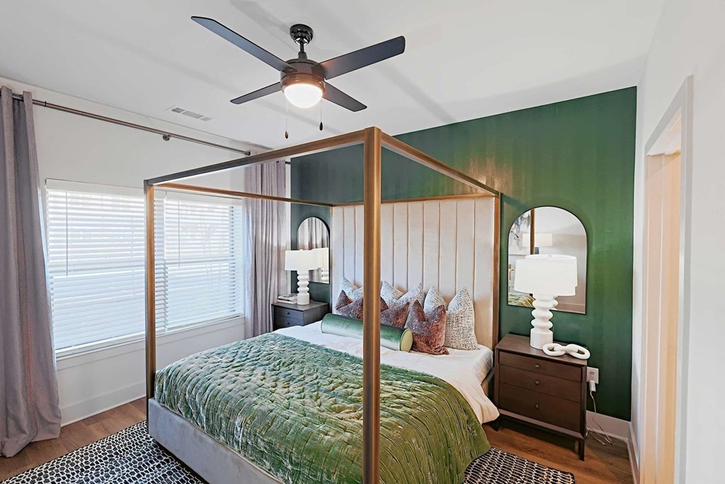 a bedroom with a four poster bed and a ceiling fan