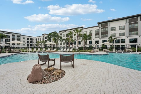A pool area with a rock in the middle of the pool.