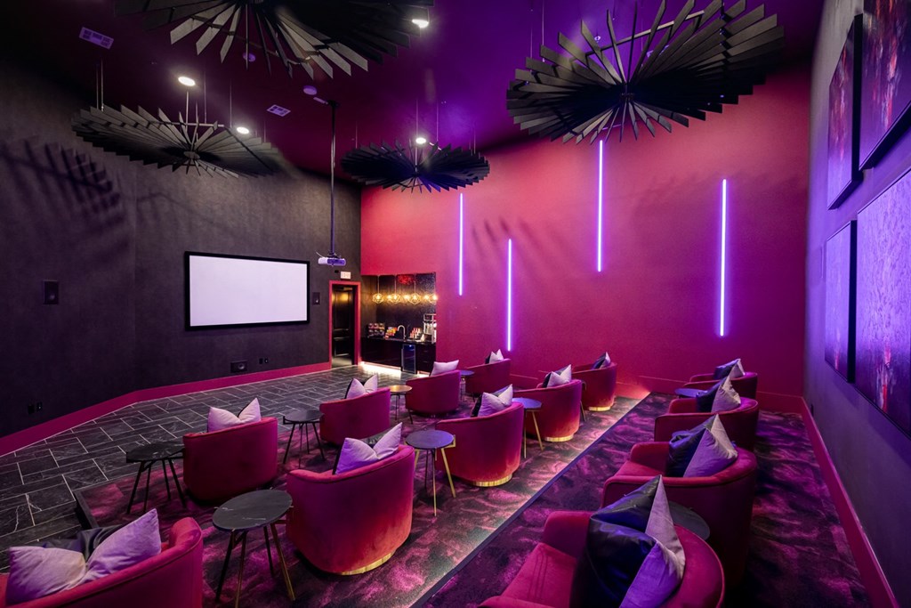 a large room with purple and pink chairs and a projector