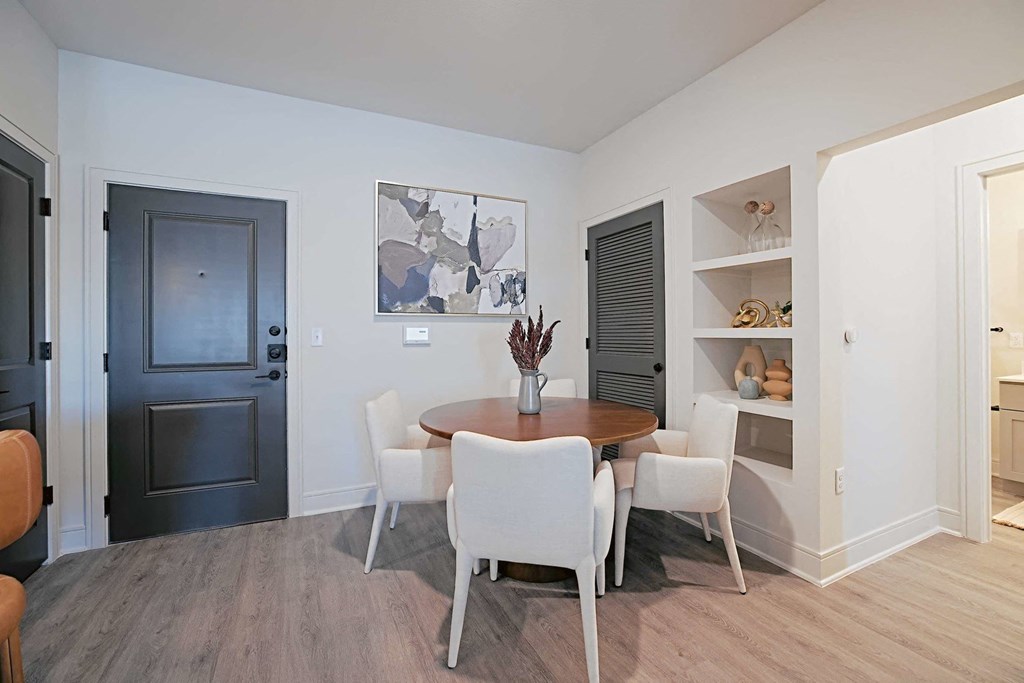 a dining room with a table and chairs and a black door