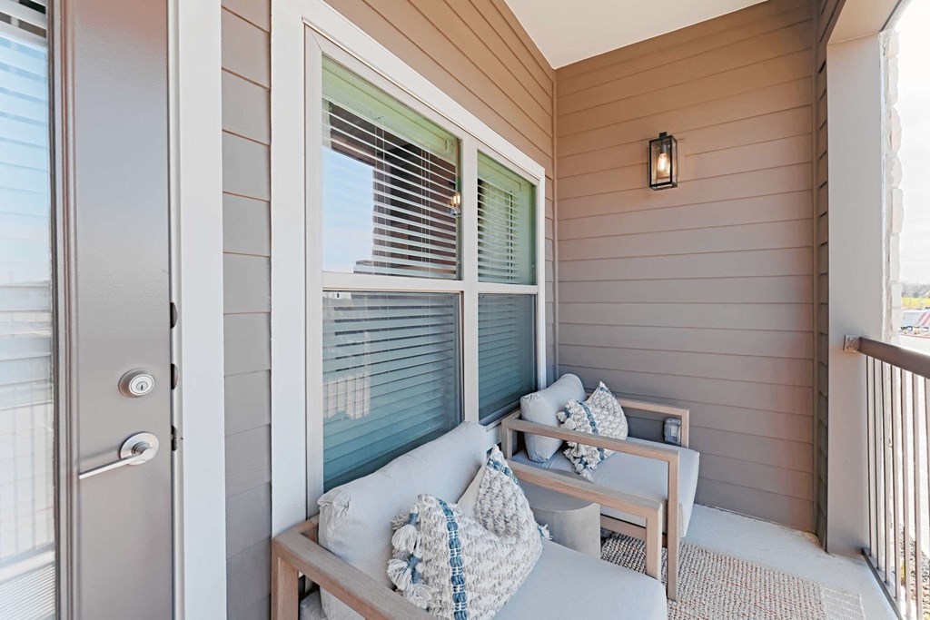 a small porch with a couch and a chair