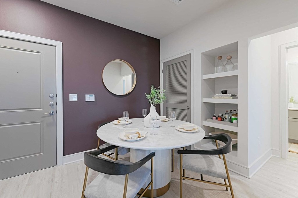 a dining room with a table and chairs and a purple wall