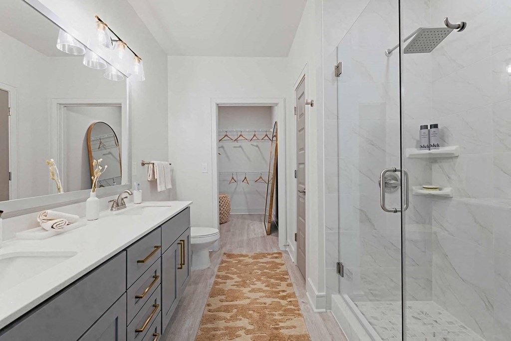 a white bathroom with a shower and a sink