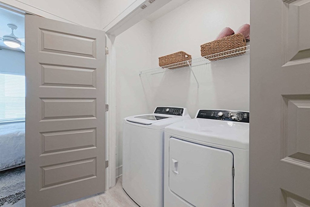 a white washer and dryer in a laundry room with a door