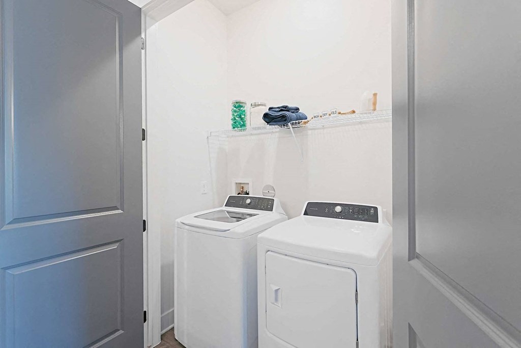 a white laundry room with two washes and a dryer