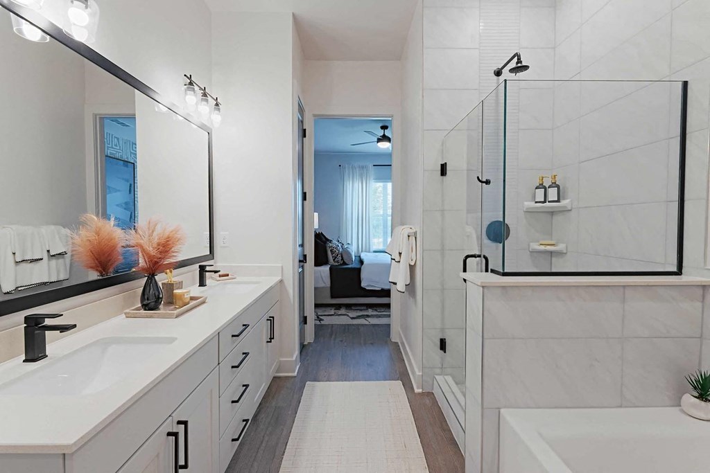 a white bathroom with two sinks and a shower