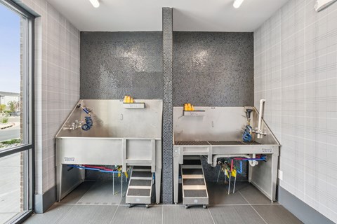 A modern kitchen with two sinks and a large window.