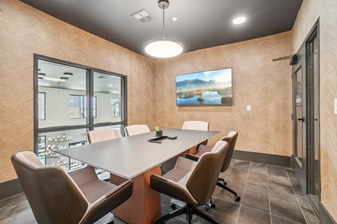 A conference room with a long table and chairs.