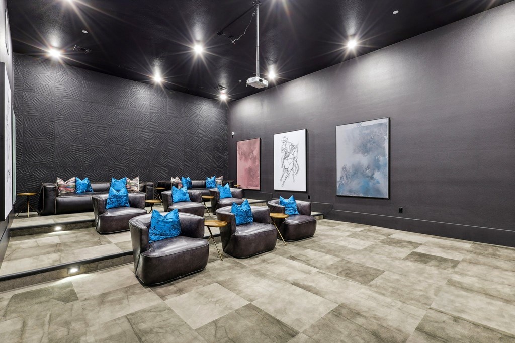 a large screening room with couches and chairs and paintings