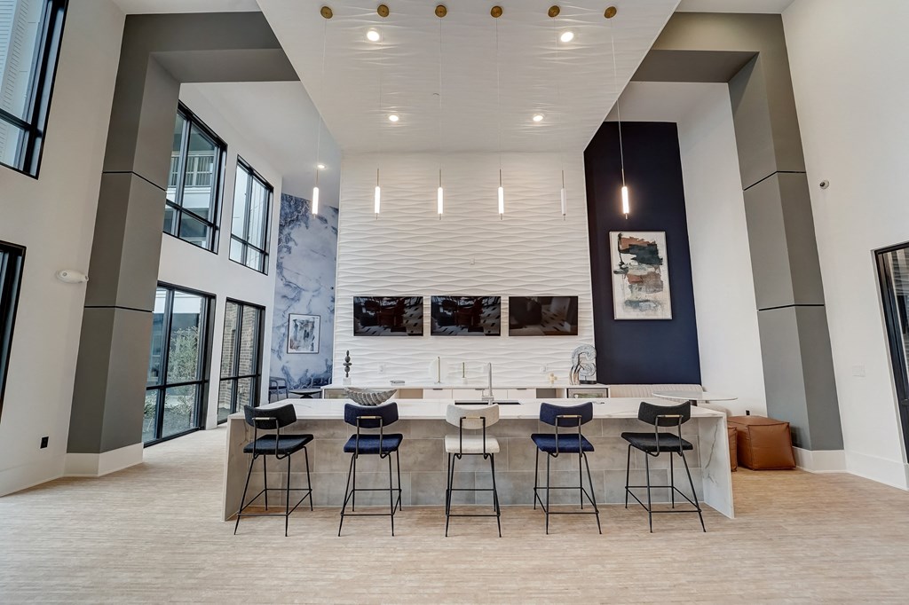 a large room with a bar and chairs and a large window