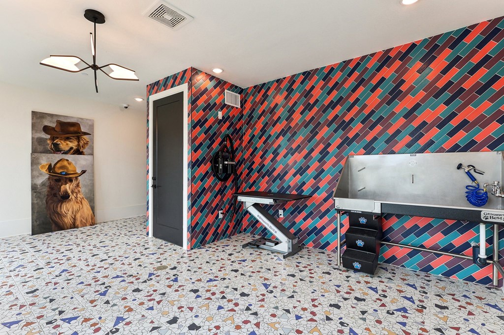 a bathroom with a sink and a urinal and a colorful tiled wall
