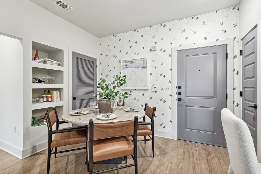 a dining room with a table and chairs and a gray door