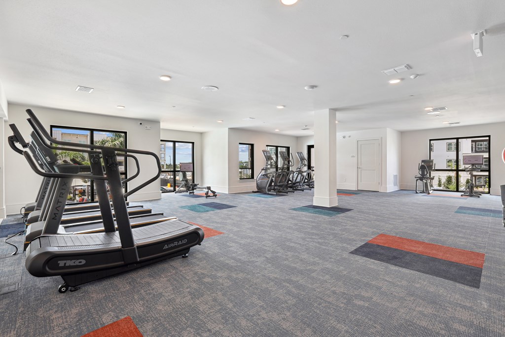 A gym with a treadmill and exercise bikes.