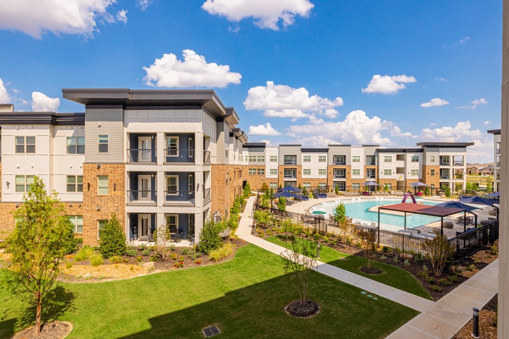 an exterior view of an apartment building with a swimming pool