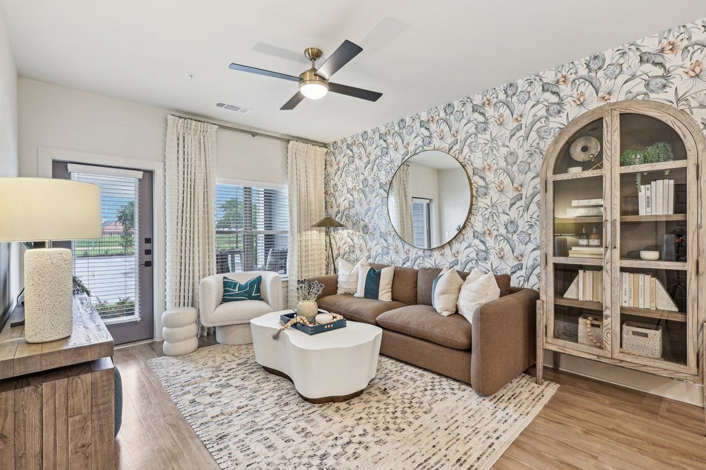a living room with a couch and a chair and a ceiling fan