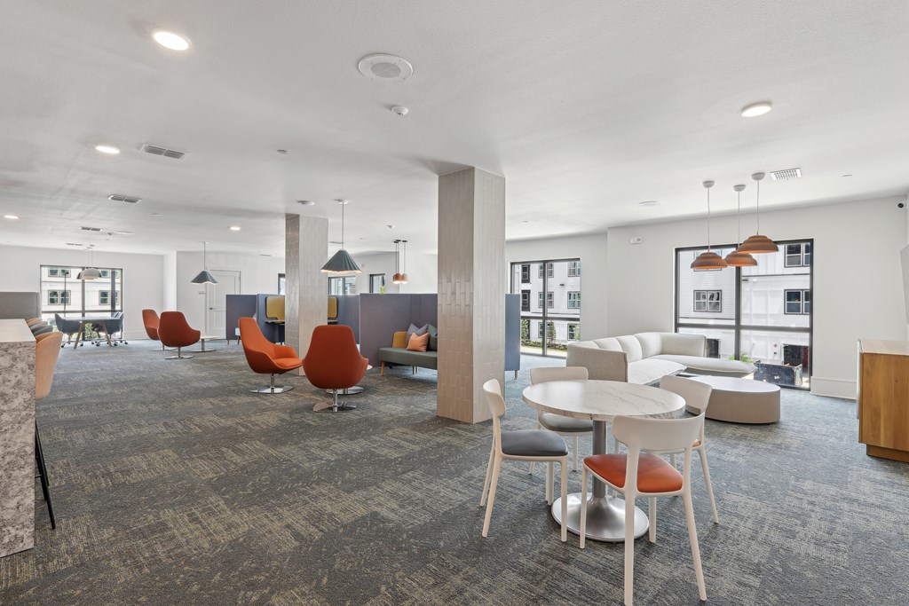 A spacious room with a grey carpet and modern furniture.