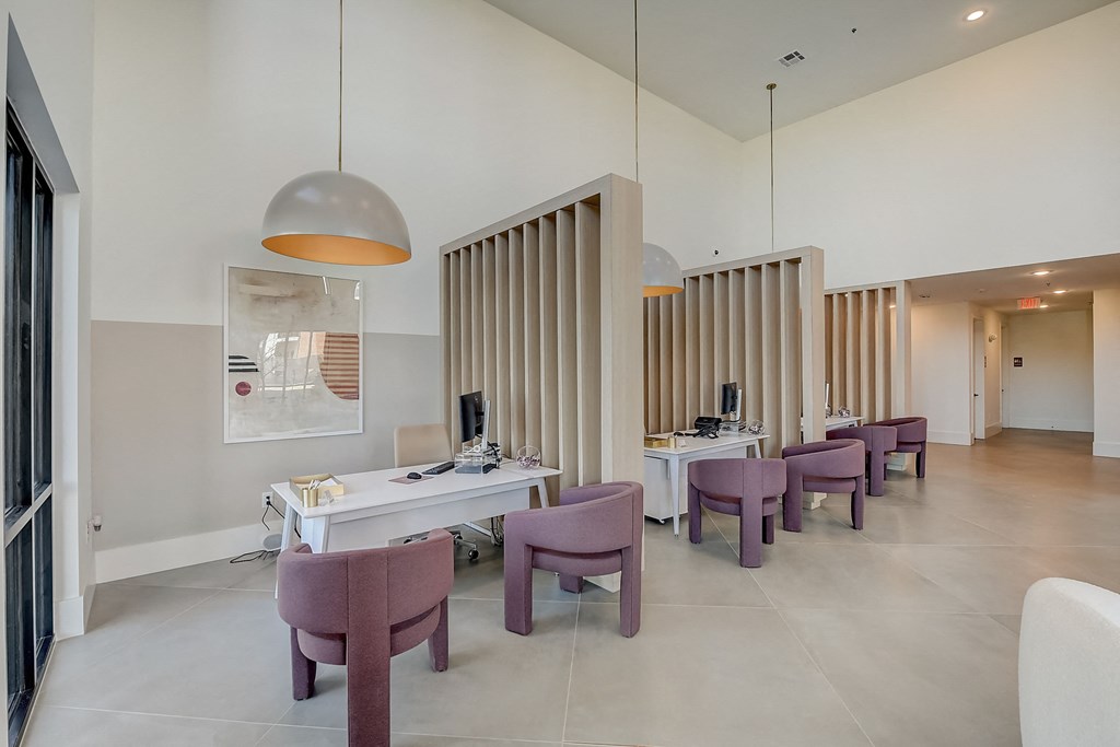 a reception area with chairs and desks and a row of tables and chairs
