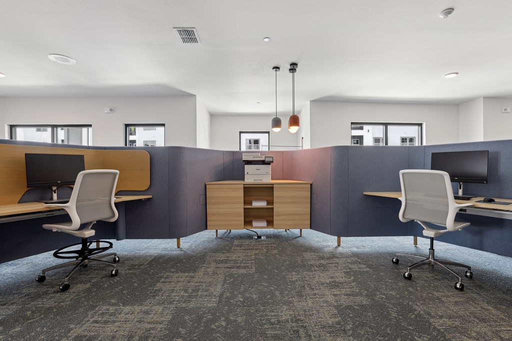 A modern office space with two desks and chairs.