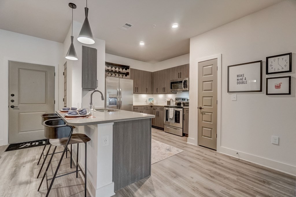 an open kitchen and dining area with a large island and stools