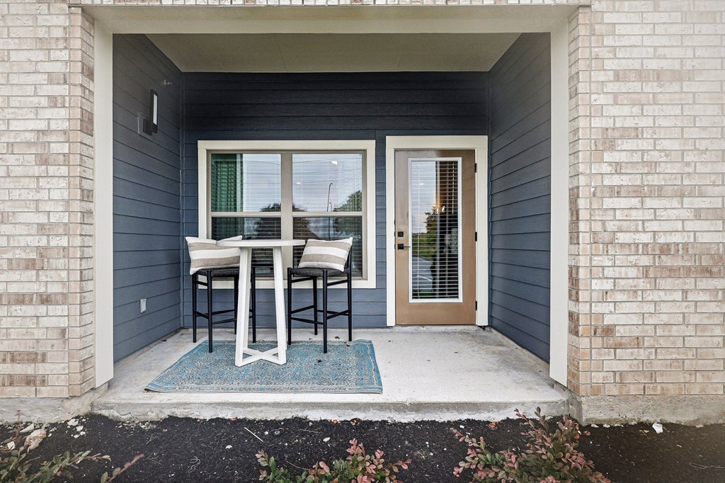 a patio with a table and chairs on the backdoor of a house