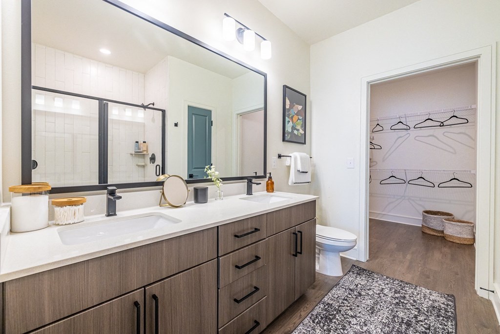 a bathroom with a large mirror and a sink and a toilet
