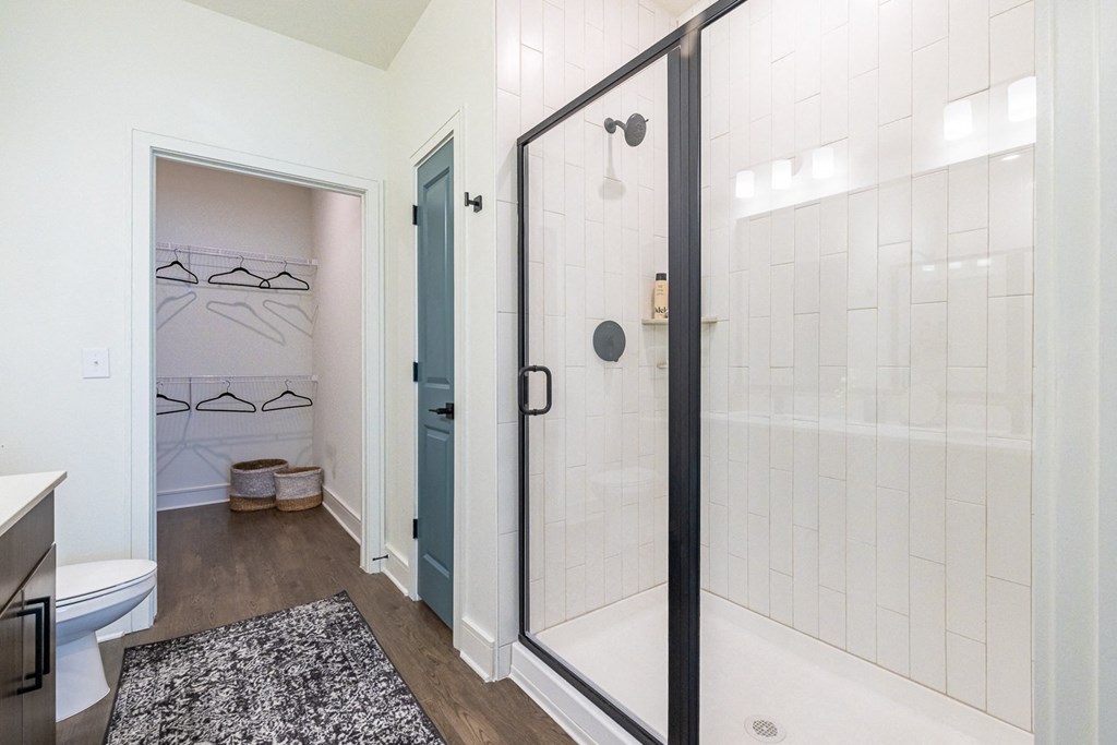 a white bathroom with a shower and a toilet