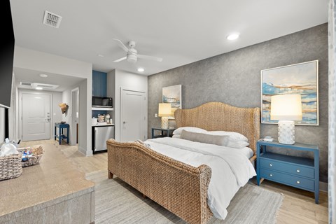 A bedroom with a bed, nightstand, and a ceiling fan.
