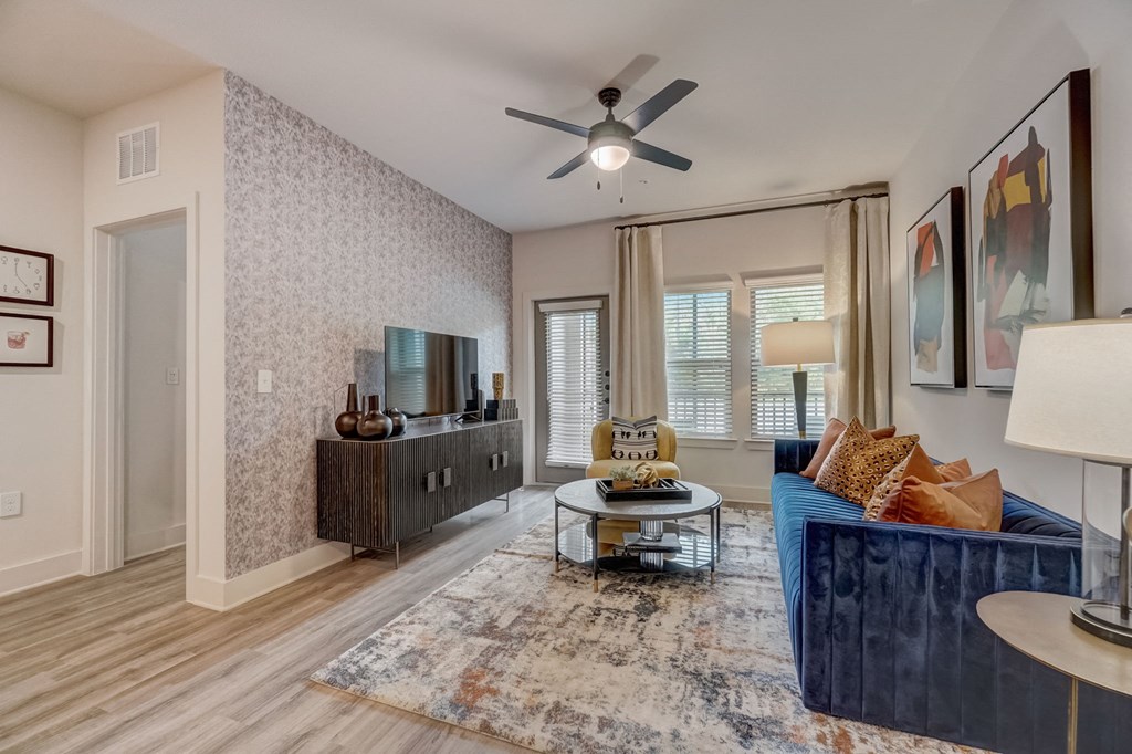 a living room with a blue couch and a ceiling fan