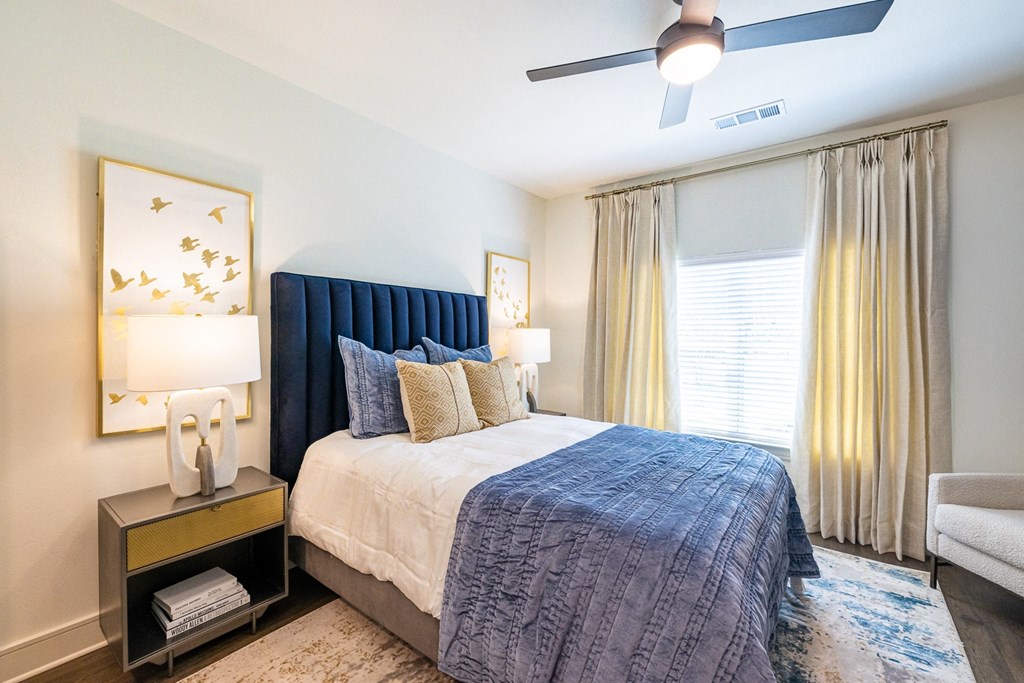 a bedroom with a large bed and a ceiling fan