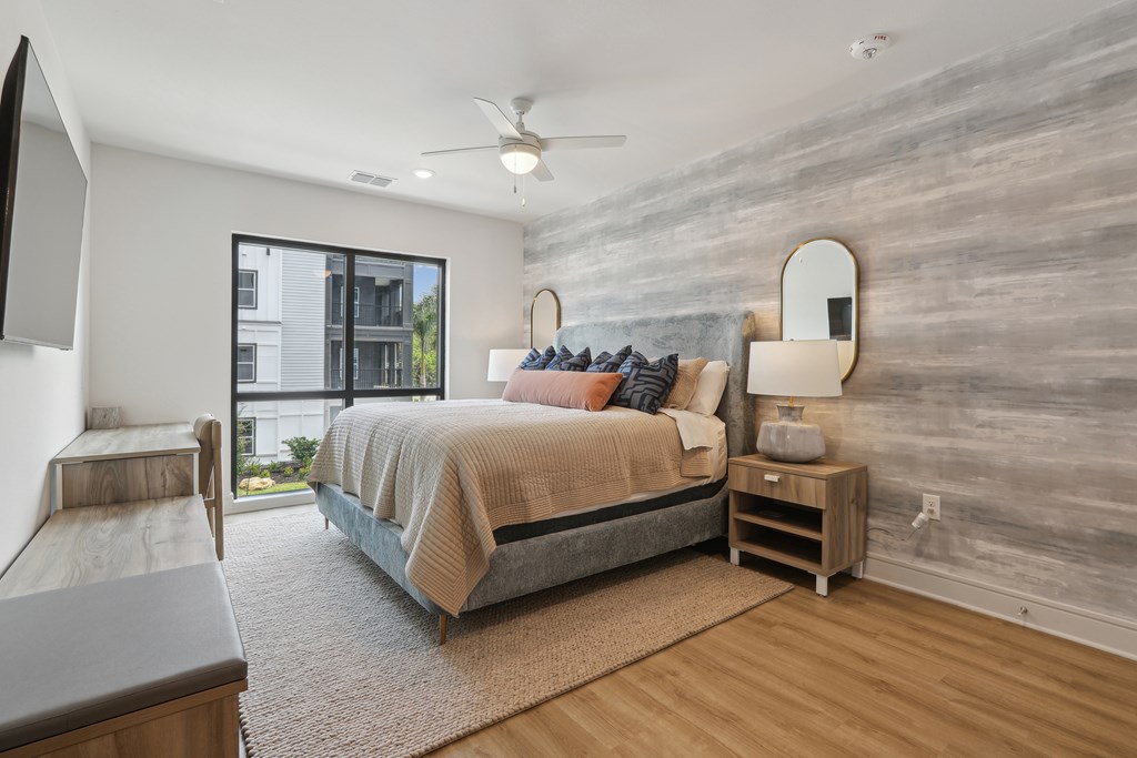 A bedroom with a bed, nightstand, and a ceiling fan.