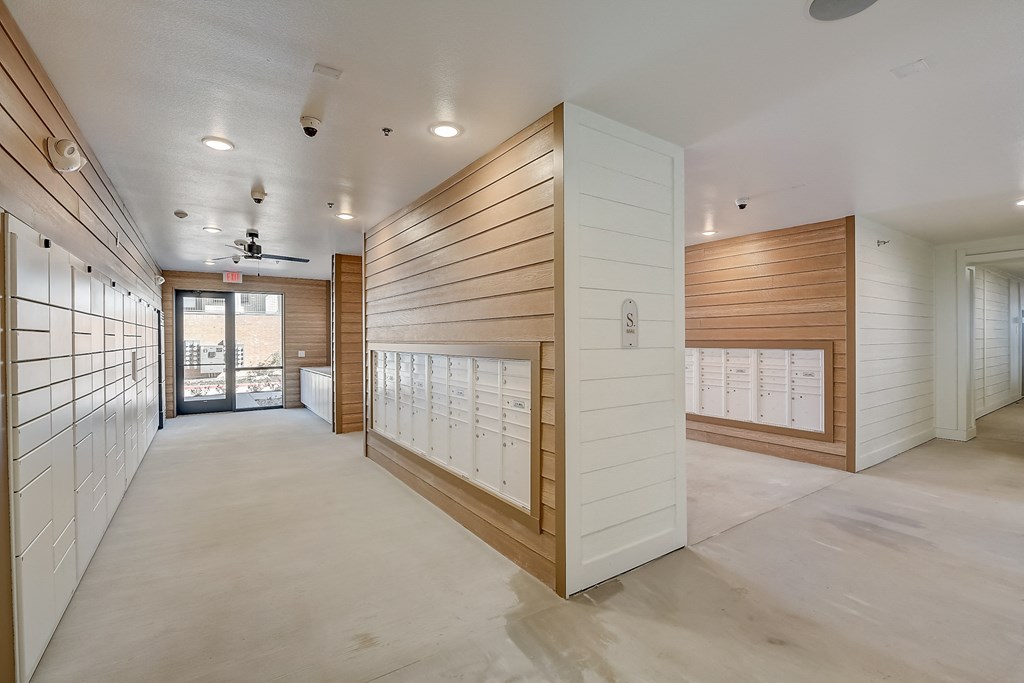 a long hallway with wooden lockers and a door to a building