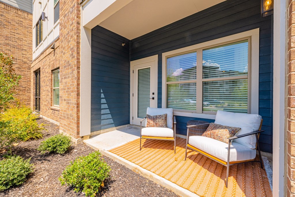 a porch with two chairs and a table on it