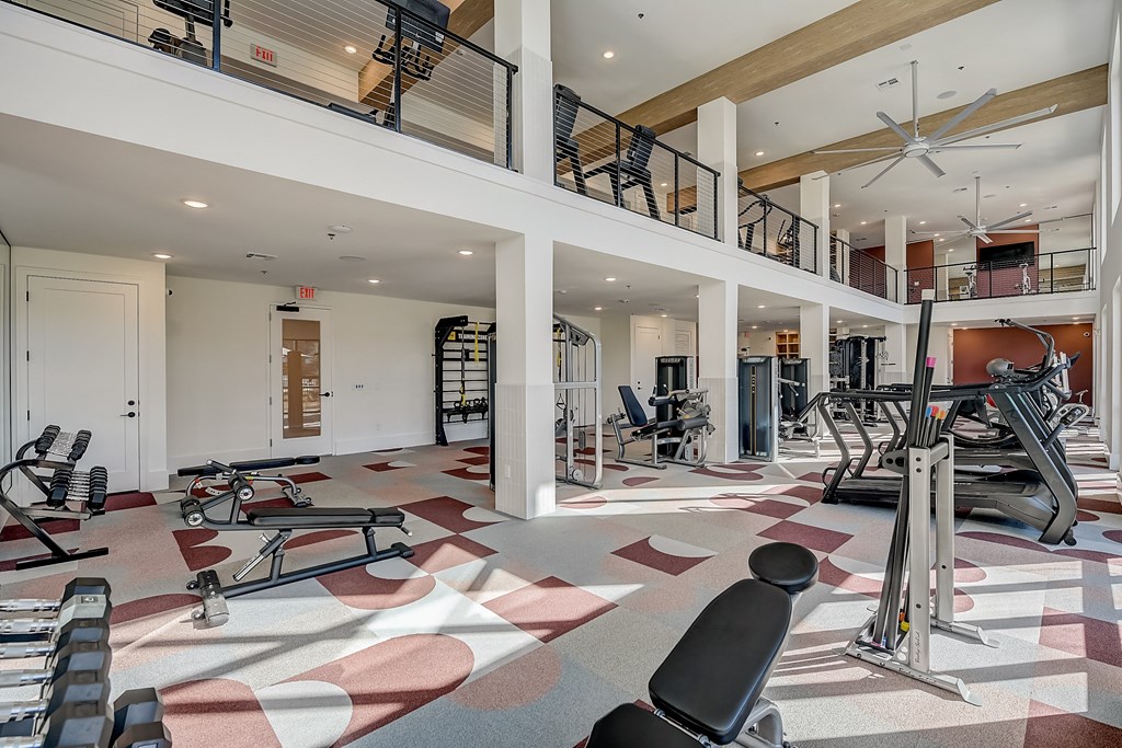 a gym with treadmills and other exercise equipment in a building with a staircase