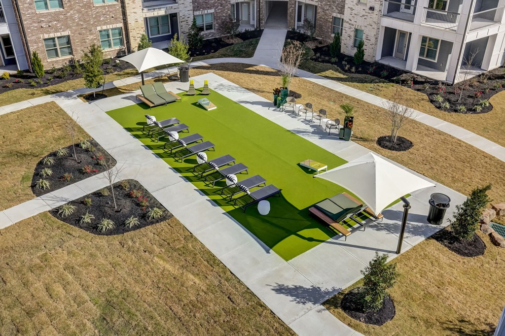 an aerial view of a yard with tables and chairs and green grass